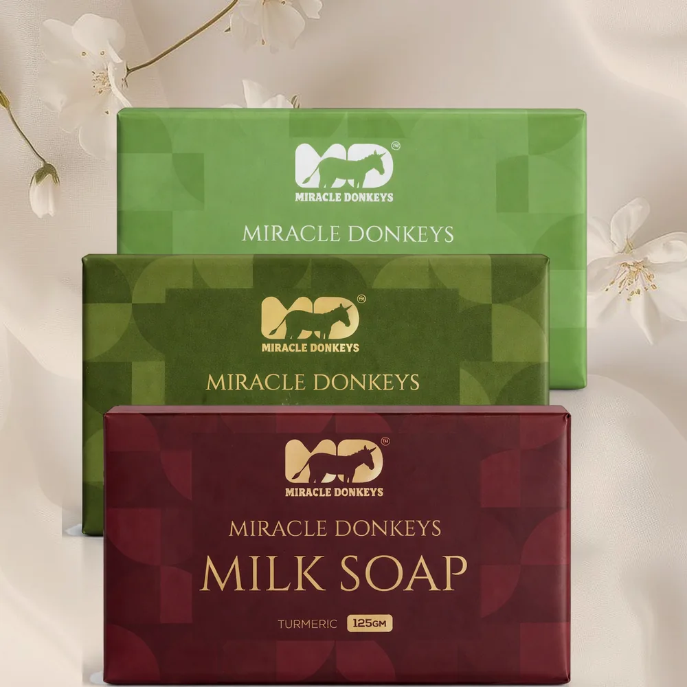 The three Miracle Donkeys milk soap packs stacked on silk
