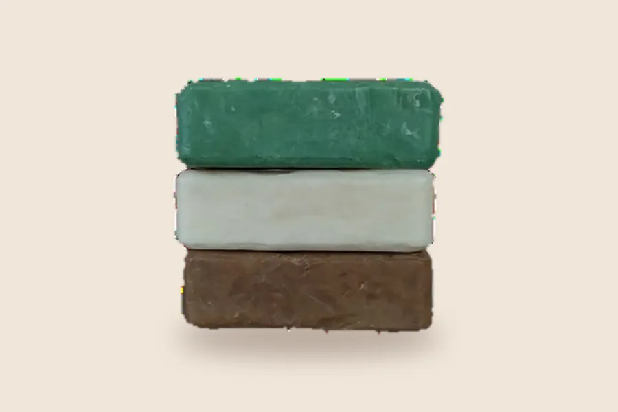 Three unwrapped handmade donkey milk soap bars stacked